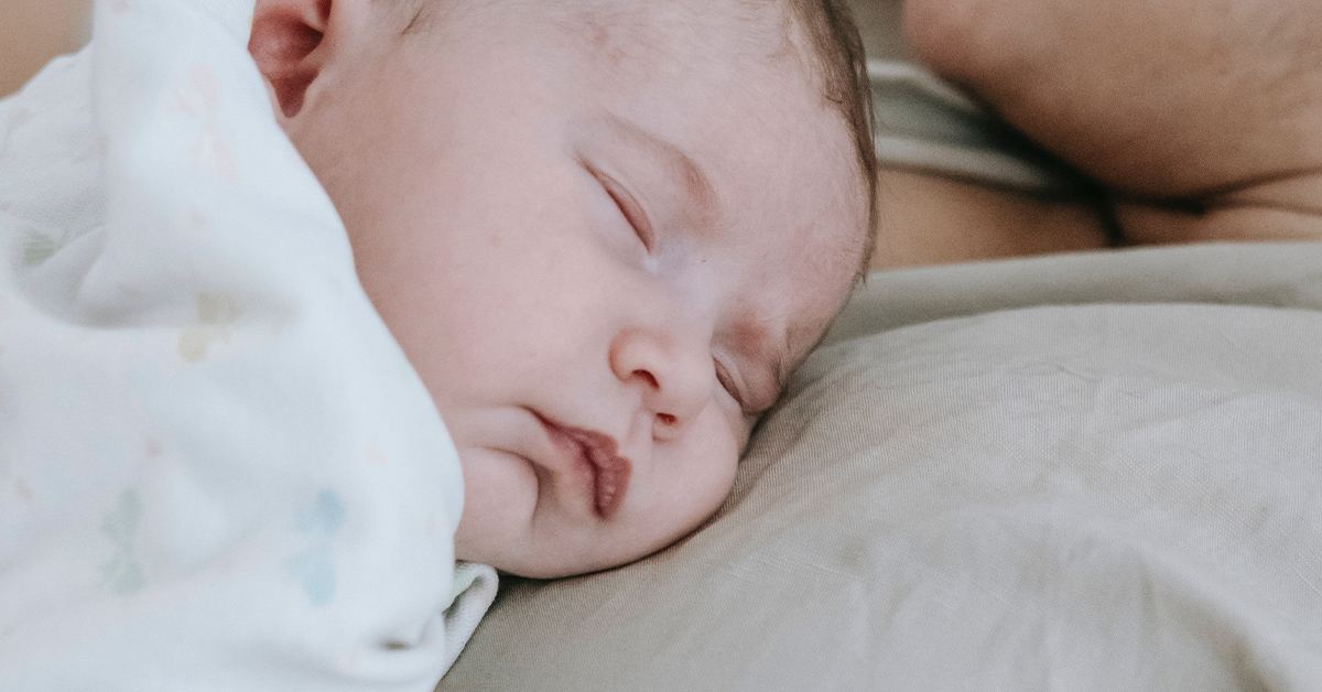 Close up of newborn baby sleeping on mothers chest