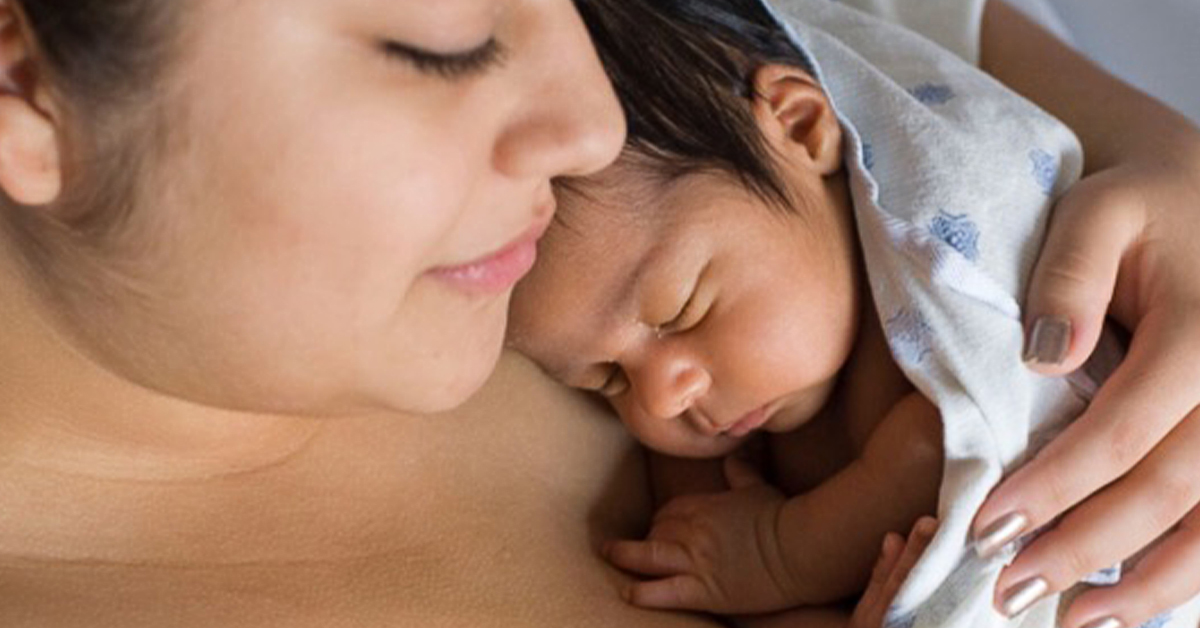 A newborn baby sleeps on mothers chest