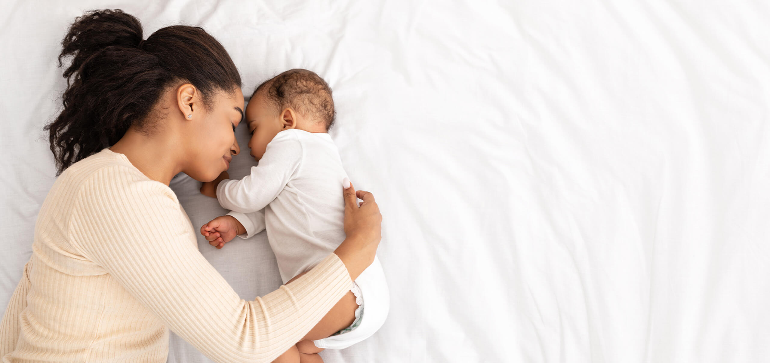 young mother sleeping with infant